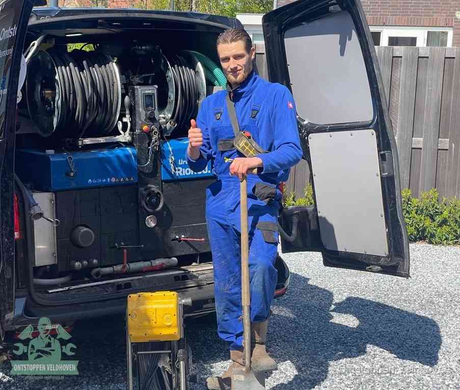 Een tevreden monteur met opgestoken duim naast de bestelbus, slim ingrijpen bespaart kosten bij een verstopte afvoer in Veldhoven