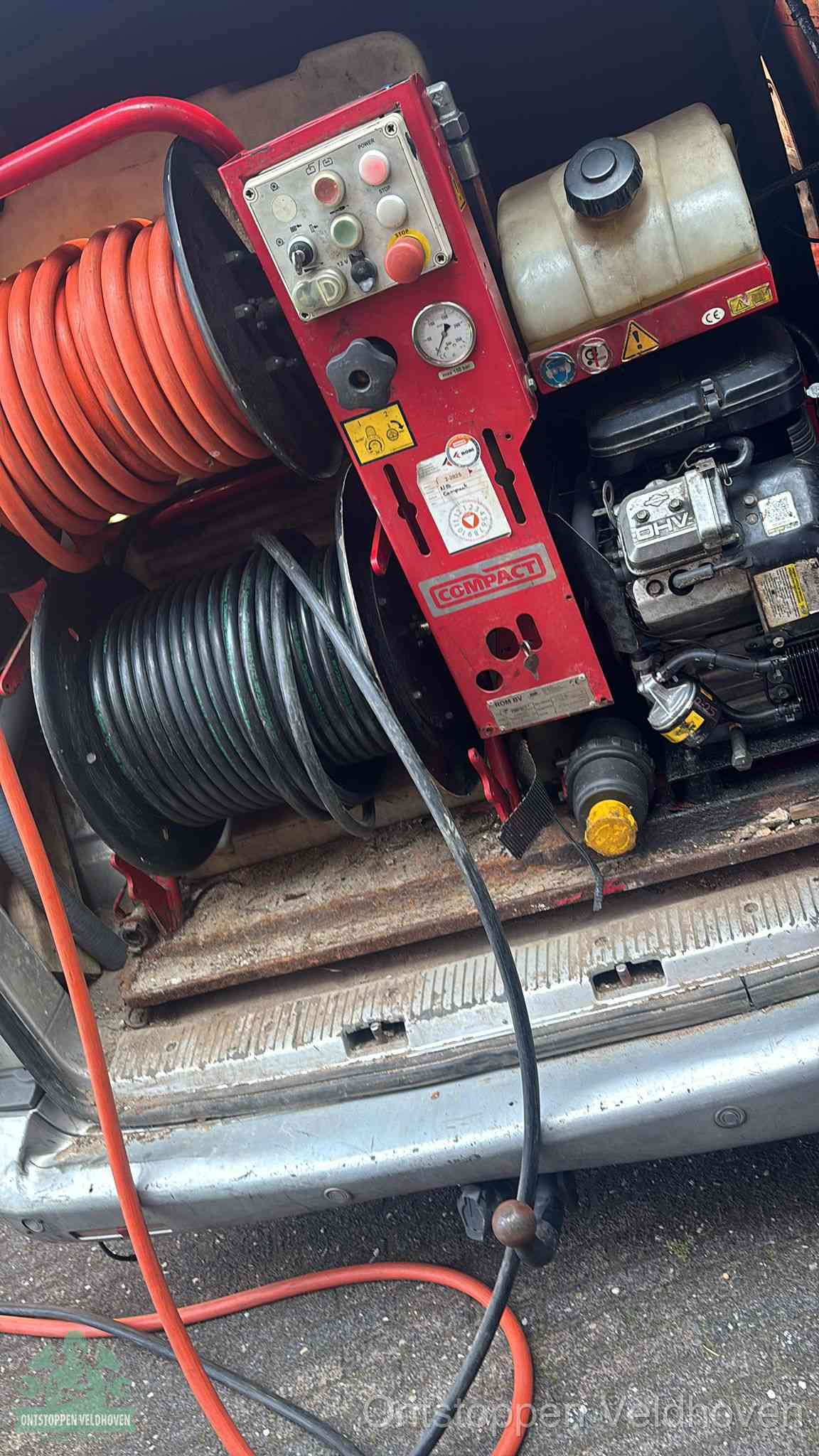 Een rood hogedruk-rioolreinigingstoestel in de laadbak van de bedrijfsbus, apparatuur voor een hardnekkige afvoerverstopping in Veldhoven
