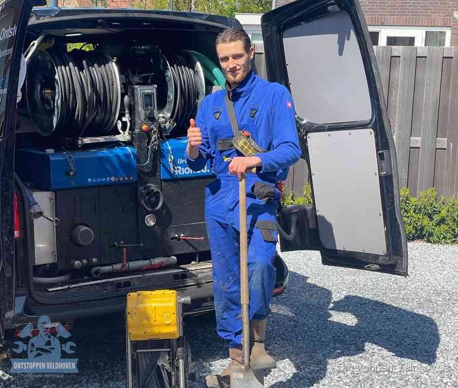 Een monteur bij de werkbus met grote hogedruk-slanghaspels, apparatuur voor hardnekkige afvoerverstoppingen in Veldhoven