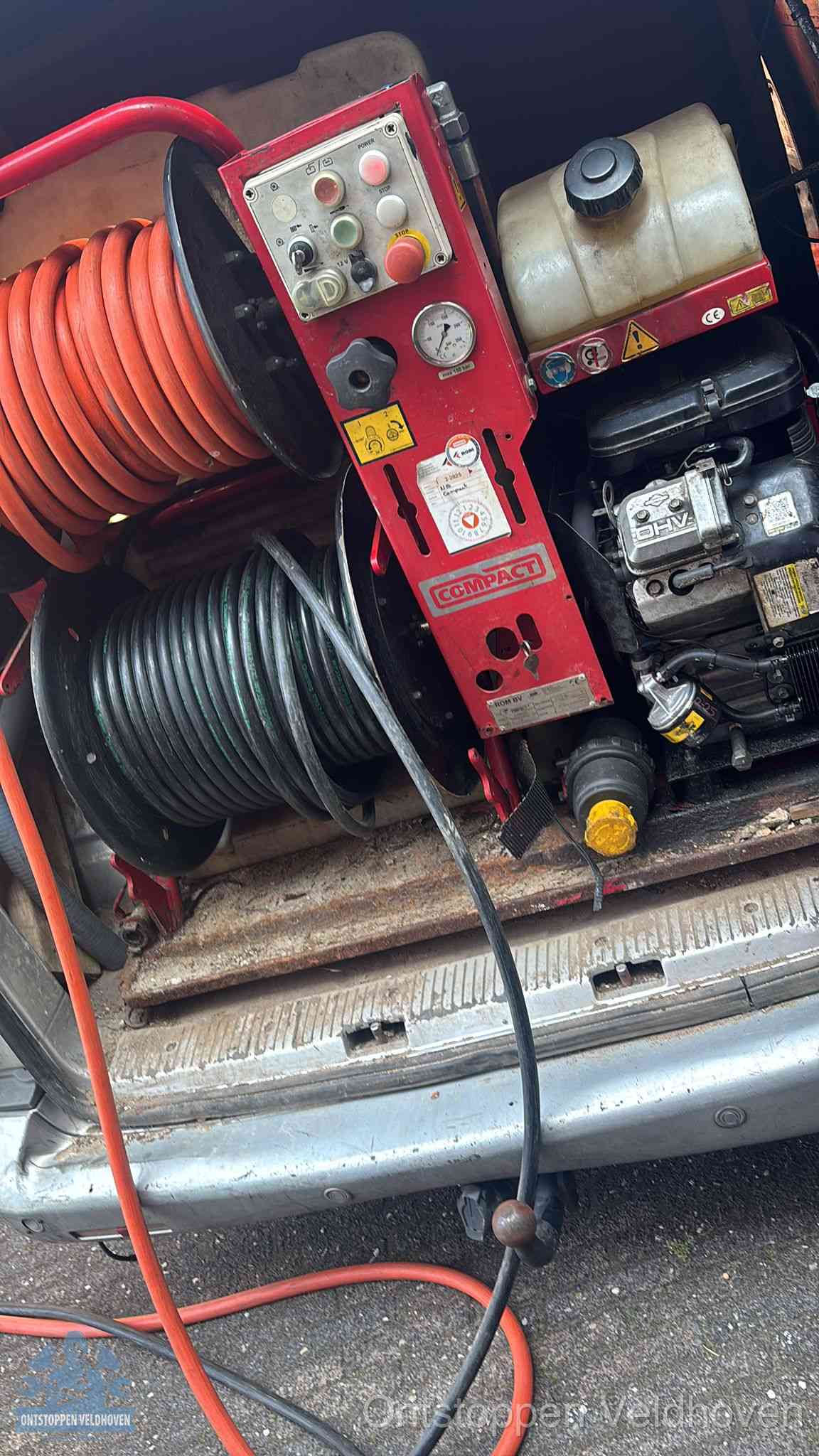Een rood hogedruk-rioolreinigingstoestel met slangen in de laadbak van de bedrijfsbus, apparatuur voor een hardnekkige wc-verstopping in Veldhoven