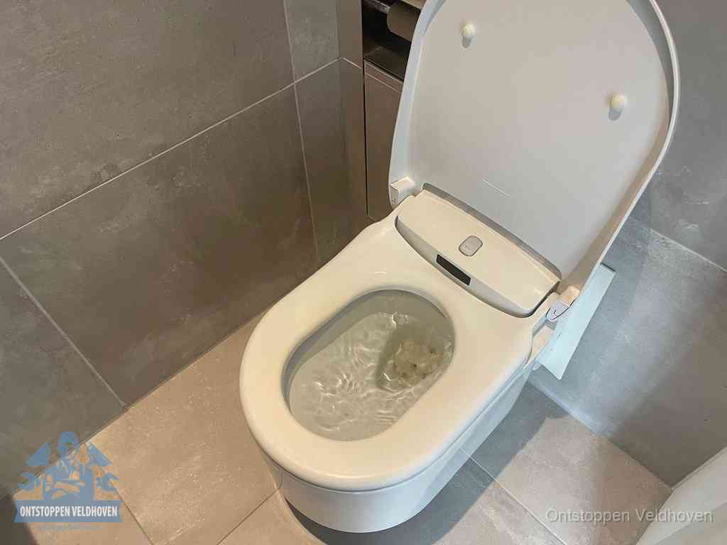 Een toiletpot vol troebel water met drijvend papier en restanten, de meest voorkomende oorzaak van een verstopte wc in Veldhoven