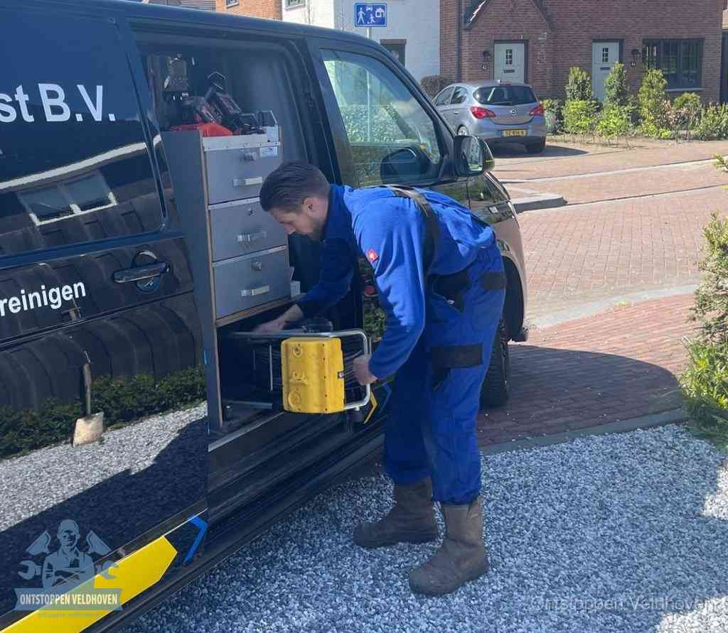 Een monteur pakt apparatuur uit de bedrijfsbus voor service aan huis, het moment om een professional in te schakelen voor een verstopte wc in Veldhoven